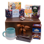 Ahmad Tea Christmas Sweet Indulgence gift set featuring Winter Wonder tea, fruity and herbal blends, cake, ceramic mug and teaspoons.